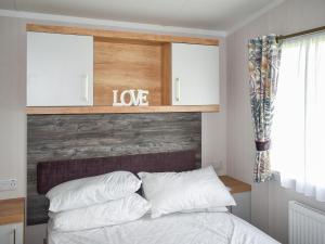 a bedroom with a bed with a wooden headboard at Apple Grove 110 - Ukc9393 in Exmouth