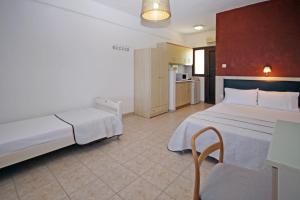 a hotel room with a bed and a kitchen at Studios Stella Vourvourou in Vourvourou