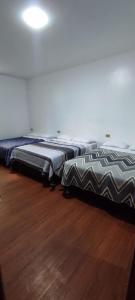 two beds sitting on a wooden floor in a room at HOTEL CASA RUSTICA Jr CALLAO 264 HUAMANGA AYACUCHO in Ayacucho