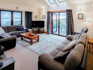 a living room with a couch and a table at Sealladh Lingeigh in Pollachar
