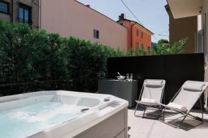 a bath tub sitting on a patio with two chairs at La Terrazza - Private Jacuzzi in Downtown Como in Como +11 photos