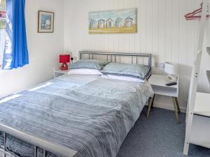 a bedroom with a bed and a nightstand and a bed sidx sidx sidx sidx at Sandy Cott in Kilkhampton