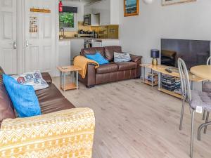 a living room with two couches and a kitchen at Sandy Cott in Kilkhampton