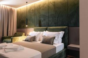 a hotel room with a bed and a chair at Cuni Luxury Hotel in Sarandë