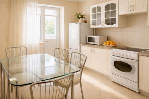 a kitchen with a glass table and a microwave at Apartment Deluxe on Moscow Avenue in Chişinău