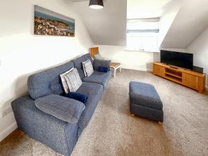 a living room with a blue couch and a tv at Top O' The Brewery in Scarborough