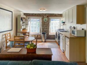 a kitchen with a table with a bowl of fruit on it at Cauldron Falls in West Burton
