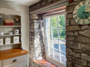 a clock on a stone wall next to a window at Cauldron Falls in West Burton