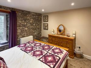 a bedroom with a bed and a dresser and a mirror at Cauldron Falls in West Burton
