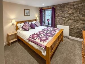 a bedroom with a bed and a stone wall at Cauldron Falls in West Burton