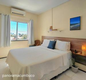 a bedroom with a large white bed with a window at Panorama Cumbuco in Cumbuco +12 photos