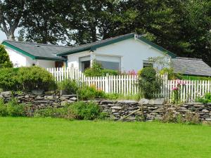 a white house with a fence and a yard at Fron - Cottage in Mynfford