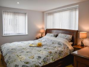 a bedroom with a bed with a tray of orange juice on it at Swallowtail Lodge in Brundall