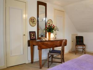 a desk with a mirror and a vase of flowers on it at Avenel Cottage in Town Yetholm