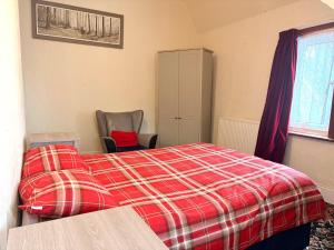 a bedroom with a bed with a red plaid blanket at Ramsgate Corner Retreat in Ramsgate