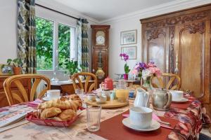 a breakfast table with croissants and pastries on it at Chambres D'hôtes De Kersehen in Plouider