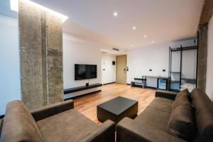 a living room with a couch and a flat screen tv at Cuni Luxury Hotel in Sarandë