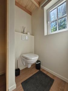 a bathroom with a toilet and a window at In het sprookjesbos in Zonnebeke