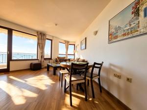 a dining room with a table and chairs with a view at Europroperties Sirena Apartaments in Golden Sands