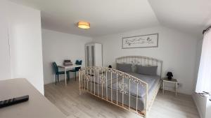 a white bedroom with a bed and a desk at Agnieszkas Pension in Havelberg
