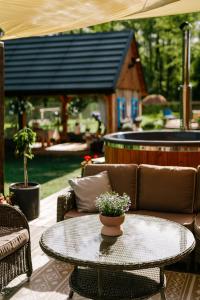 a patio with a table and chairs and a house at Gardiasówka na Roztoczu in Chlewiska