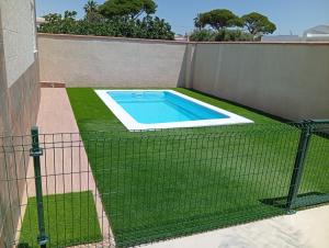 a fence around a swimming pool in a yard at El Descanso in Conil de la Frontera