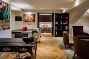 a living room with a table and chairs and a bed at Hotel Schweizerhof Bern & Spa in Bern