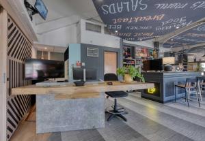 a bar in a restaurant with a desk and chairs at B&B HOTEL Bordeaux Mérignac Cadera Aéroport in Mérignac