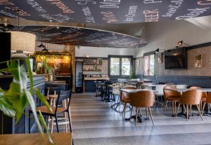 a restaurant with tables and chairs and a bar at B&B HOTEL Bordeaux Mérignac Cadera Aéroport in Mérignac