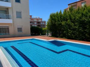 a large blue swimming pool next to a building at Апартамент Солана - Apartment Solana in Lozenets