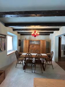 ein Esszimmer mit Tisch, Stühlen und Kronleuchter in der Unterkunft Chalet Angelo in Ponte di Legno