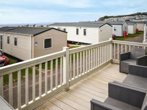 a deck with a fence and a house at Apple Grove 24 in Exmouth