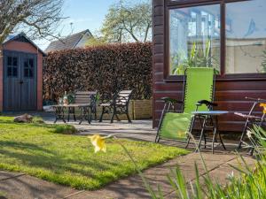 a yard with chairs and tables and a house at Applepips in Stirling