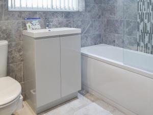 a bathroom with a white sink and a toilet at White Towers - Hw7625 in Llandwrog