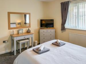 a bedroom with a bed and a mirror and a television at White Towers - Hw7625 in Llandwrog