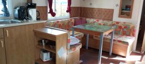 a living room with a couch and a table at le 130 mobile home à Meschers sur Gironde au camping L'escale in Meschers-sur-Gironde