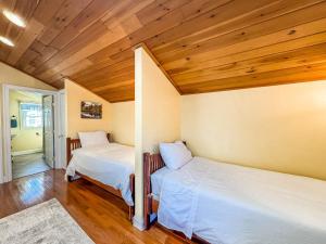 two beds in a room with wooden ceilings at New: Charming and Cozy Great Value in Swanton
