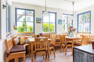 a dining room with tables and chairs and windows at Strandmuschel in Born
