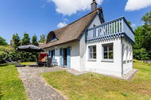 a small white cottage with a roof at Strandmuschel in Born