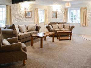 a living room with couches and tables and windows at Cider Cottage - E5576 in Warkleigh