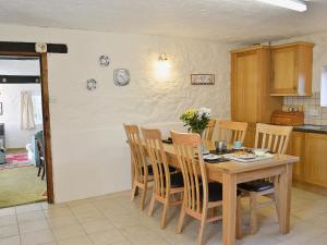 a kitchen with a wooden table and chairs at Cider Cottage - E5576 in Warkleigh