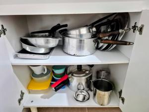 a shelf with pots and pans and other kitchen utensils at Casa no centro de Poços de Caldas in Poços de Caldas +8 photos