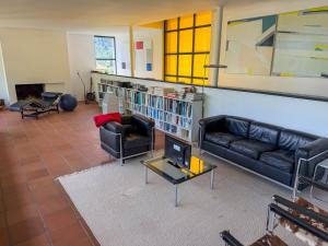 a living room with two leather couches and a fireplace at Villa Cavalli in Verscio