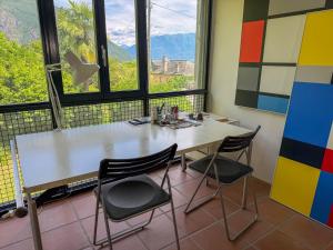 a table and chairs in a room with a view at Villa Cavalli in Verscio