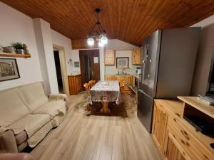 a living room with a table and a kitchen at Apartment Pineta Alben 2 in Serina