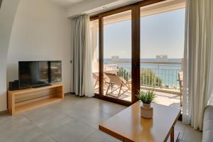 ein Wohnzimmer mit Fernseher und Meerblick in der Unterkunft Valtos Beach Hotel in Parga