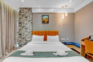 a bedroom with a bed with two hats on it at Hotel Cachet in Coimbatore