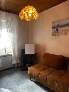 a living room with a couch and a chandelier at Ruheoase in Konz-Könen in Konz