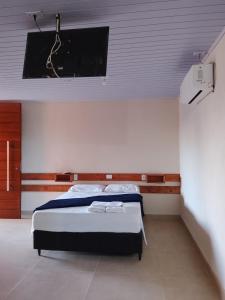 a bedroom with a bed and a flat screen tv at Pousada laranja in Xangri-lá