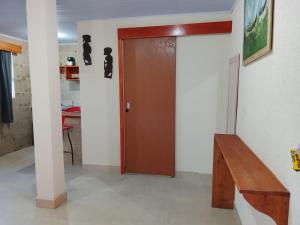 a wooden door in a room with a wooden bench at Pousada laranja in Xangri-lá